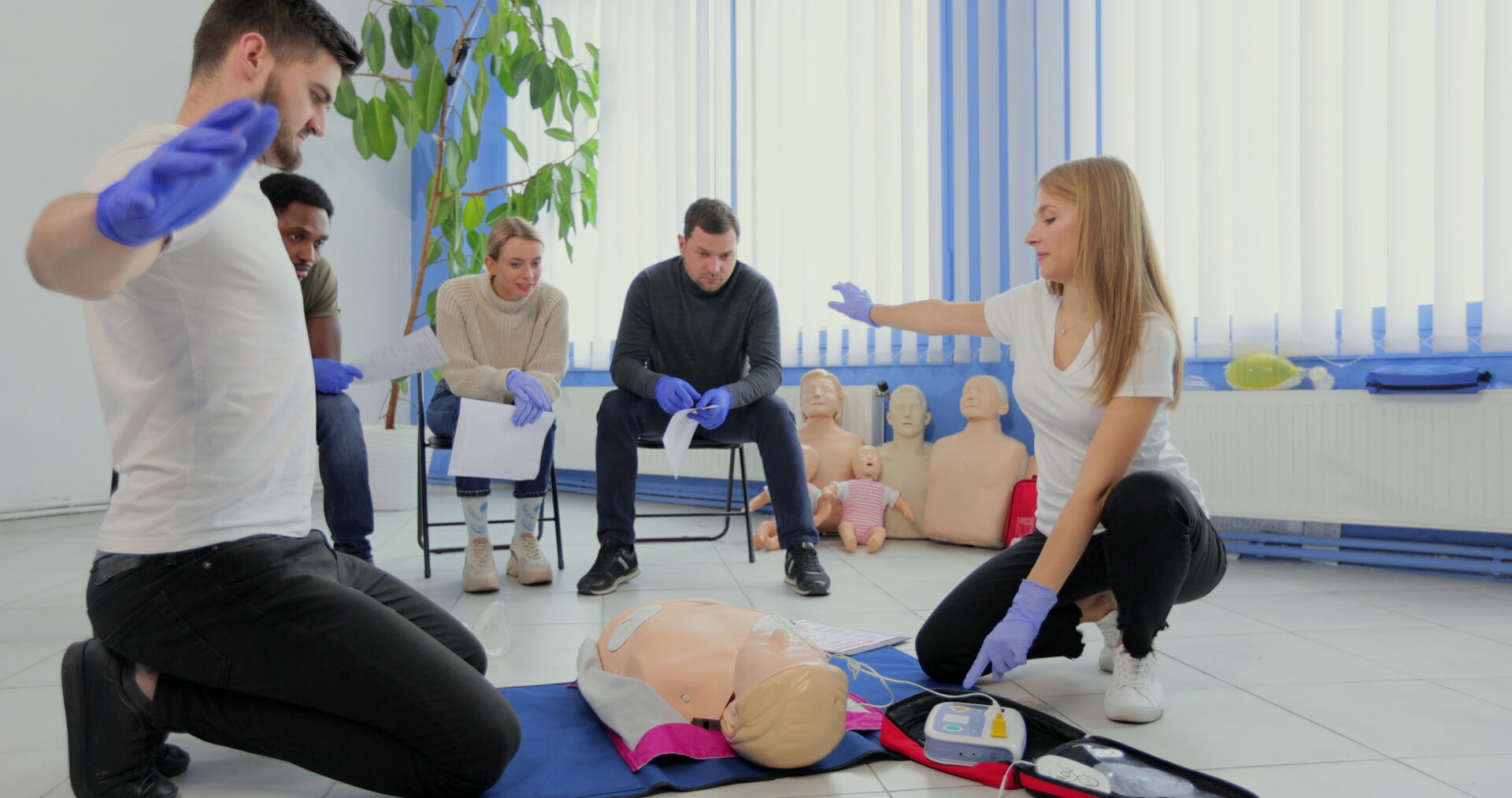 Stay away moment during the defibrillation process on a first aid group training indoors