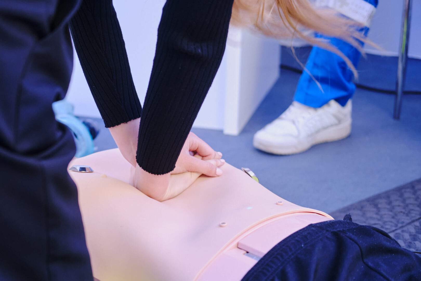 First aid training. Paramedic hand doing first aid to a mannequin patient